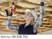 woman using drill on indoor construction site. Стоковое фото, агентство Ingram Publishing / Фотобанк Лори