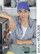 woman in her 50s fixing a computer. Стоковое фото, агентство Ingram Publishing / Фотобанк Лори