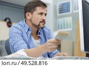 a man holding four paintbrushes. Стоковое фото, агентство Ingram Publishing / Фотобанк Лори
