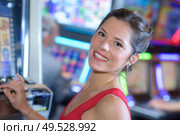 happy girl playing slot machines in las vegas. Редакционное фото, агентство Ingram Publishing / Фотобанк Лори