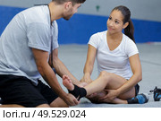 woman with sprained ankle and getting help from man. Стоковое фото, агентство Ingram Publishing / Фотобанк Лори