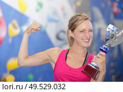 portrait of female raising gold trophy to celebrate. Стоковое фото, агентство Ingram Publishing / Фотобанк Лори
