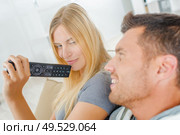 Playful couple fighting over the TV remote. Стоковое фото, агентство Ingram Publishing / Фотобанк Лори