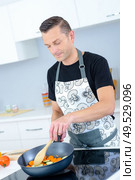 a man stirring the vegetables. Стоковое фото, агентство Ingram Publishing / Фотобанк Лори