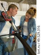 a man and woman changing windshield. Стоковое фото, агентство Ingram Publishing / Фотобанк Лори