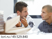 two men holding timber on woodworking machine. Стоковое фото, агентство Ingram Publishing / Фотобанк Лори