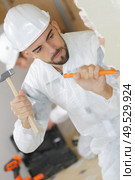 young man contactor with a chisel and hammer. Стоковое фото, агентство Ingram Publishing / Фотобанк Лори
