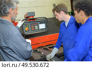 apprentices looking at a machine. Стоковое фото, агентство Ingram Publishing / Фотобанк Лори