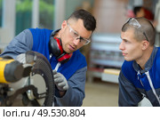 apprentice and man working in a factory. Стоковое фото, агентство Ingram Publishing / Фотобанк Лори
