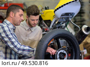 dad and son checking a motorbike. Стоковое фото, агентство Ingram Publishing / Фотобанк Лори