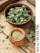 Bowl with dried oregano on old wooden table. Dried marjoram seasoning. Стоковое фото, агентство Ingram Publishing / Фотобанк Лори