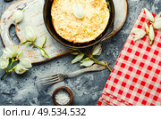 Frying pan with scrambled eggs stuffed with edible yucca flowers.American food. Omelet with edible flowers. Стоковое фото, агентство Ingram Publishing / Фотобанк Лори