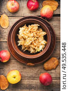 Grated ripe autumn apples in a plate on a wooden old table. Grated ripe apples. Стоковое фото, агентство Ingram Publishing / Фотобанк Лори