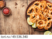 Fried squid rings breaded with lime on wooden background. Crispy fried squid rings. Стоковое фото, агентство Ingram Publishing / Фотобанк Лори