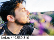 Young man in a field of flowers, a tale of a new masculinity. Стоковое фото, агентство Ingram Publishing / Фотобанк Лори
