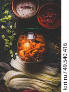 Fermented chinese cabbage marinated in hot chili sauce, kimchi,  in glas jar on rustic background with ingredients. Top view. Стоковое фото, агентство Ingram Publishing / Фотобанк Лори