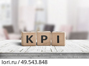 KPI word on a wooden sign in a bright environment with furniture in the background. Стоковое фото, агентство Ingram Publishing / Фотобанк Лори
