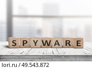 Spyware word on wooden cubes in a bright office on a white painted desk. Стоковое фото, агентство Ingram Publishing / Фотобанк Лори