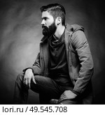 Portrait of handsome man with beard and mustache. Close-up image of serious brutal bearded man on dark background. Black and white photography. Стоковое фото, агентство Ingram Publishing / Фотобанк Лори