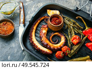 Grilled octopus with roasted vegetables in grill pan.Delicious grilled seafood. Grilled octopus with vegetable. Стоковое фото, агентство Ingram Publishing / Фотобанк Лори