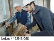 builders checking mineral wool panels stack. Стоковое фото, агентство Ingram Publishing / Фотобанк Лори