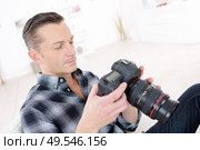 photographer in studio with dslr camera in hand. Стоковое фото, агентство Ingram Publishing / Фотобанк Лори