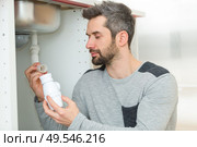 man working on kitchen sink siphon. Стоковое фото, агентство Ingram Publishing / Фотобанк Лори