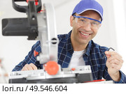 mature man holding allen key to adjust circular saw. Стоковое фото, агентство Ingram Publishing / Фотобанк Лори