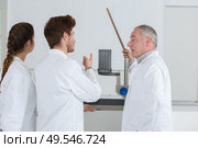 team standing grouped in front of white board. Стоковое фото, агентство Ingram Publishing / Фотобанк Лори