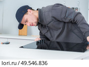 portrait of a male installing kitchen hob. Стоковое фото, агентство Ingram Publishing / Фотобанк Лори