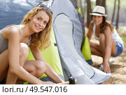 female friends pitching up their tent. Стоковое фото, агентство Ingram Publishing / Фотобанк Лори