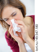 burnette woman blowing nose into tissue. Стоковое фото, агентство Ingram Publishing / Фотобанк Лори