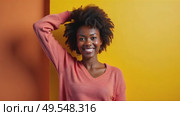 Happy smile positive woman in a color sweater stands confidently with her arm raised, positioned against a vibrant color wall, soft lighting. Black african american female cheerful dancing. Стоковое AI-видео, аниматор Sergey Grishin / Фотобанк Лори