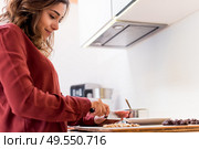 Young woman making chocolate peanut cookies. Стоковое фото, агентство Ingram Publishing / Фотобанк Лори