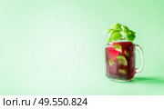 Red berries lemonade in Mason jar  flavored with herb leaves at sunny bight mint green background. Summer mood.  Healthy drinks and lifestyle. Copy space. Стоковое фото, агентство Ingram Publishing / Фотобанк Лори
