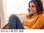 Optimistic woman sitting in a confortable rattan chair at home. Стоковое фото, агентство Ingram Publishing / Фотобанк Лори