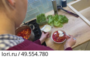 Surrounded by vegetables, a woman prepares a comforting pot of borscht, blending tradition, flavor, and warmth into each colorful bowl. Стоковое видео, видеограф Ирина Старикова / Фотобанк Лори