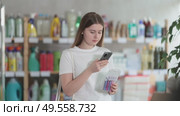Girl buyer scans qr code on razor kit label. Стоковое видео, видеограф Яков Филимонов / Фотобанк Лори