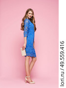 Blonde young woman in elegant blue dress. Model posing on a pink background in full length. Jewelry and hairstyle. Girl with handbag. Fashion photo. Стоковое фото, агентство Ingram Publishing / Фотобанк Лори