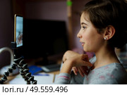 Two little girls talking via video conference with smartphone due to Covid-19 pandemic quarantine confinement. Little girls talking via video conference with smartphone. Стоковое фото, агентство Ingram Publishing / Фотобанк Лори