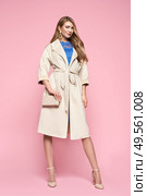 Young elegant woman in trendy white coat. Blonde hair, blue dress, isolated on pink background, studio shot. Fashion spring lookbook. Model woman with handbag. Стоковое фото, агентство Ingram Publishing / Фотобанк Лори