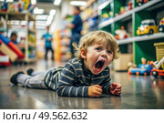 A little boy is lying on the floor in a store. Childish hysteria. The child screams, sobs, gets cranky and gets hysterical. Discontent. Стоковое AI-изображение, AI-художник Photojuli / Фотобанк Лори