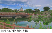 Himeji, Japan - Sep 24 2024, 4k, panoramic view of Sakuramon Bridge and entrance gate, with Himeji Castle, White Heron Castle on background, trees on foreground, at daytime, Himeji, Japan. Редакционное видео, видеограф Сергей Богомяко / Фотобанк Лори