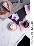 life style set at meeting in cafe.Thai blue, Butterfly pea tea served with fresh figs and panna cotta cake and fruit piece of cake on serving napkins. . Стоковое фото, агентство Ingram Publishing / Фотобанк Лори