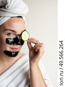 Woman removing blackheads and dark circles with cucumber at home - Home made beauty Spa. Стоковое фото, агентство Ingram Publishing / Фотобанк Лори