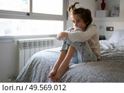 Nine-year-old girl sitting in bed at home bored by confinement. Nine-year-old girl sitting in bed bored by confinement. Стоковое фото, агентство Ingram Publishing / Фотобанк Лори