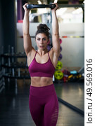 Athletic woman doing triceps push-ups with a barbell plate at the gym.. Athletic woman doing triceps push-ups with a barbell plate. Стоковое фото, агентство Ingram Publishing / Фотобанк Лори