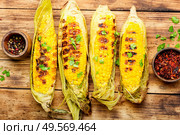 Tasty grilled corn on retro wooden table,summer food. Grilled corn cobs. Стоковое фото, агентство Ingram Publishing / Фотобанк Лори