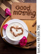 porcelain cup of coffee with ice cream and cinnamon heart served  at black wooden table with pink roses. life style concept. Стоковое фото, агентство Ingram Publishing / Фотобанк Лори