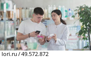 Man scans QR code on box paracetamol label. Female pharmacist offers to choose the right shampoo. Стоковое видео, видеограф Яков Филимонов / Фотобанк Лори
